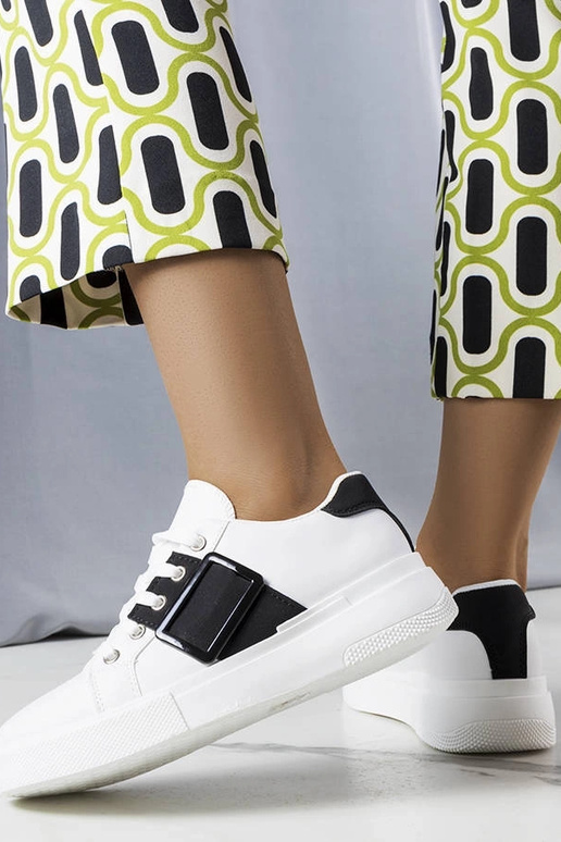 Biele tenisky zdobené čiernou prackou...