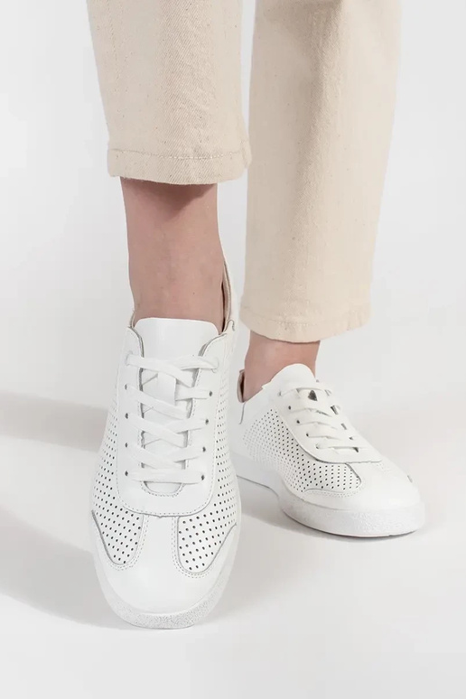 Biele športové topánky perforované z... Biele športové topánky perforované z...