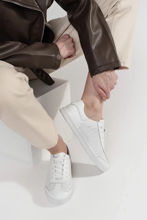 Biele športové topánky perforované z... Biele športové topánky perforované z...