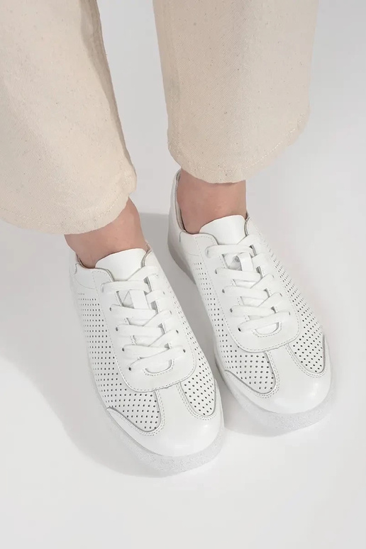 Biele športové topánky perforované z... Biele športové topánky perforované z...