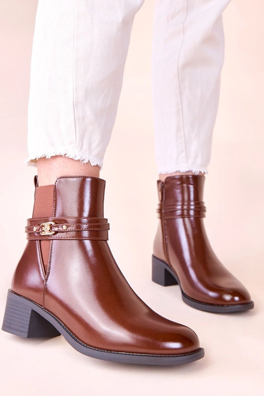 Hnedé čižmy na stĺpiku s dekoratívnym...