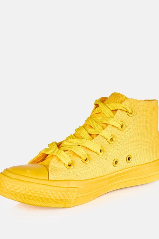 Žlté detské tenisky nad členkom Jutta