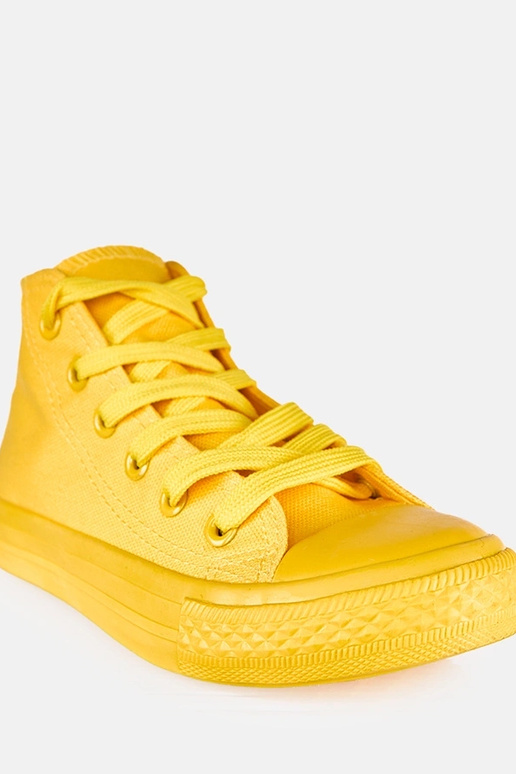 Žlté detské tenisky nad členkom Jutta